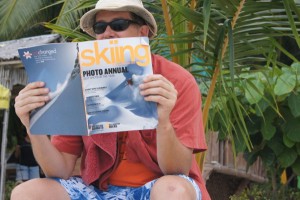 Man reading Skiing Magazine on a tropical beach -- Project A Squared
